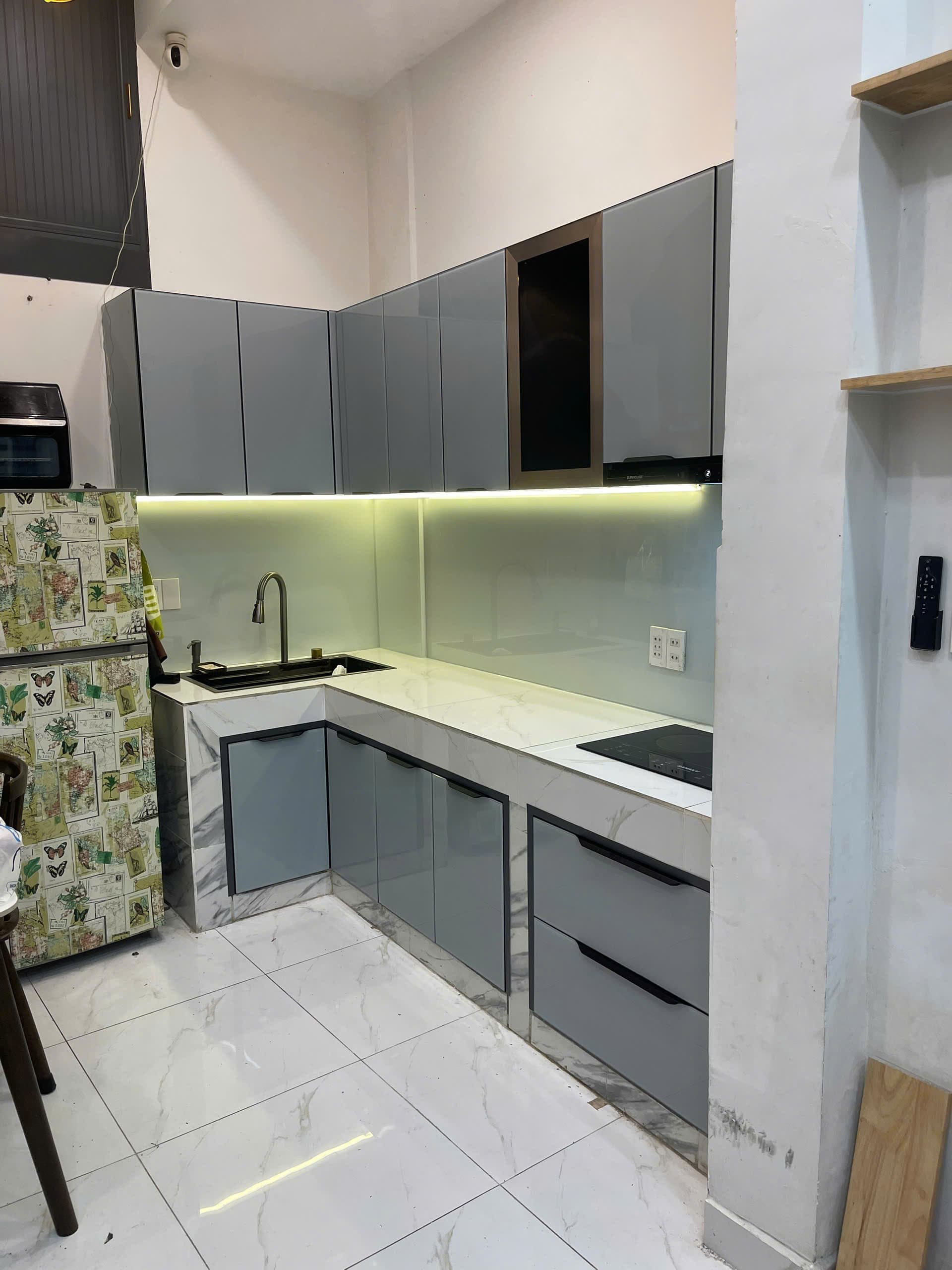 Tủ bếp chữ L cánh kính màu xám sau khi lắp đặt