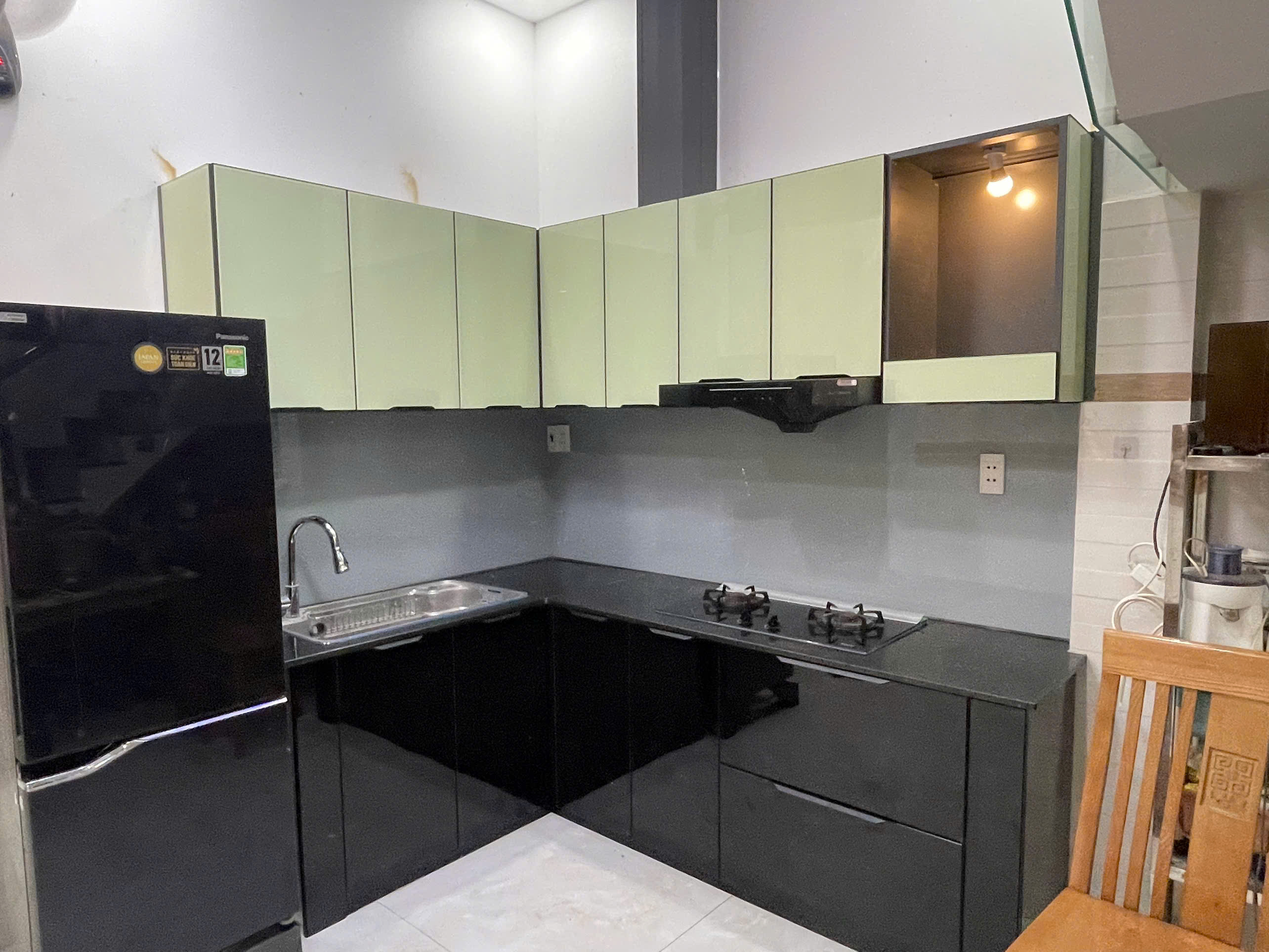 Tủ bếp chữ L phối xanh và đen được chụp trực tiếp tại công trình thực tế