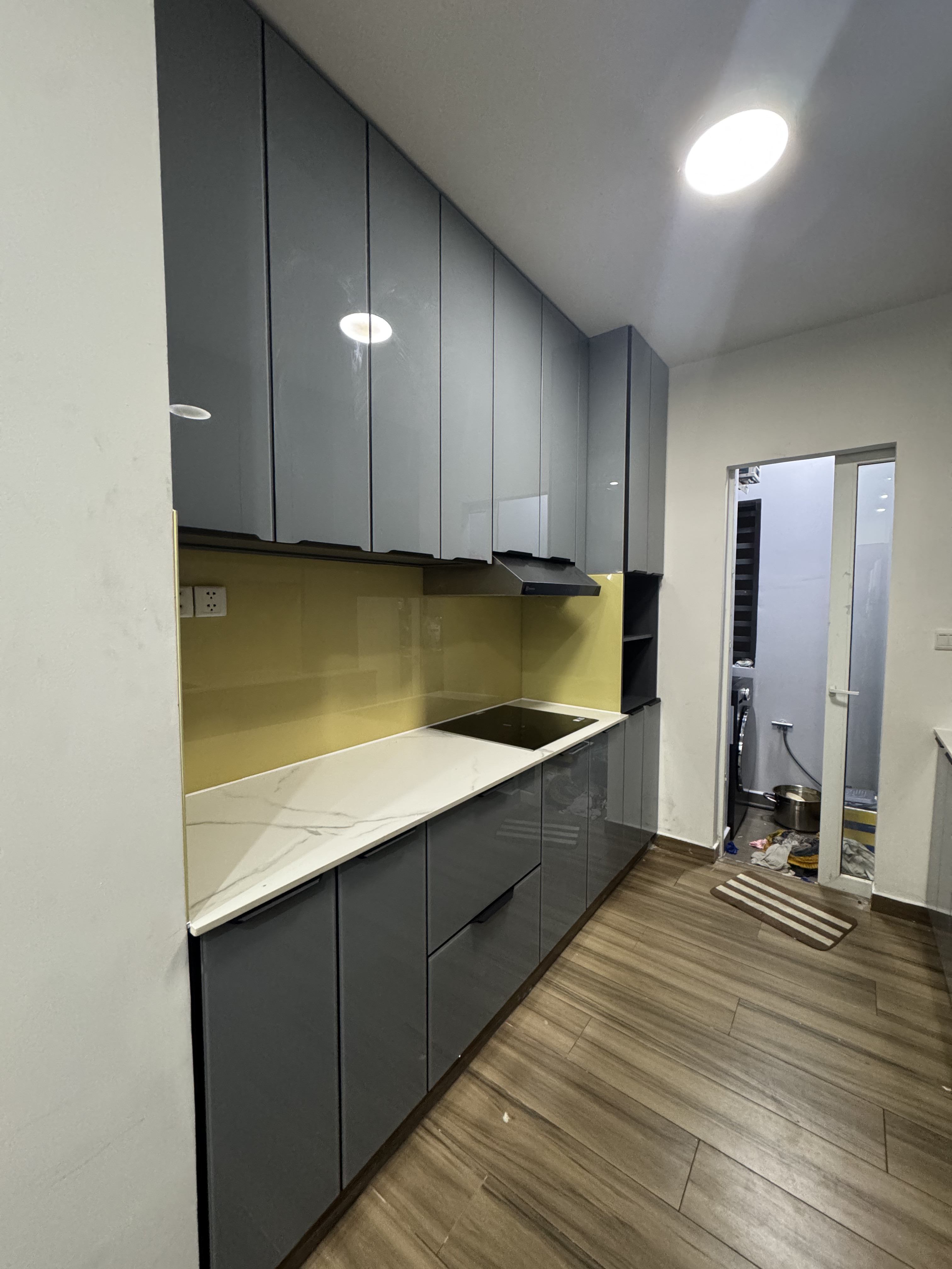 Tủ bếp cánh kính xám phối đen được chụp trực tiếp tại công trình thực tế